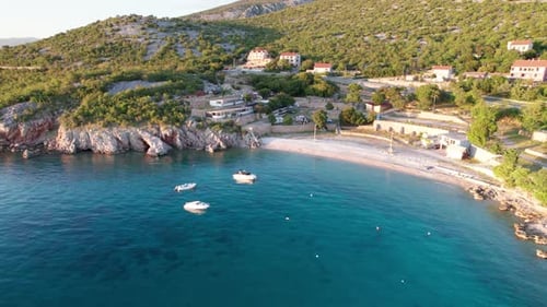 Vista aérea da costa rochosa da Croácia com acampamento e estrada curva ao pôr do sol