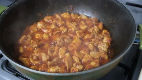 Diced Chicken Simmering in a Red Sauce