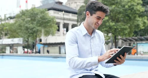 Man Using Tablet Outdoors in Urban Setting