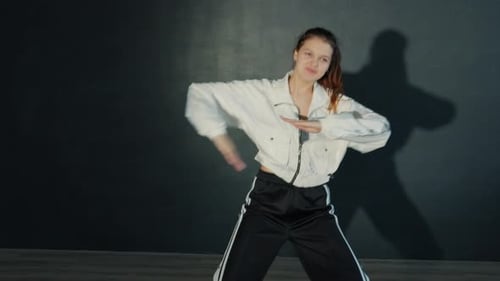 Attractive Teenager in Sports Clothing Dancing in Dark Studio with Illumination