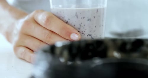 Pouring Blueberry Smoothie into Glass at Home