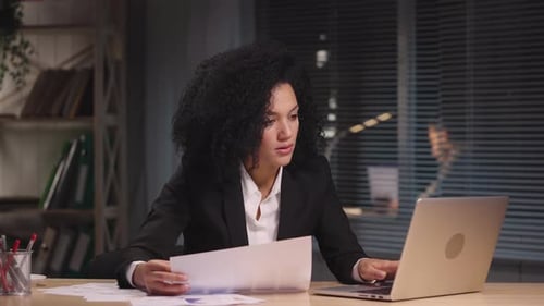 Professional Woman Works Diligently at Desk Late Night