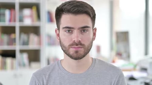 Young Man Close Up Portrait Indoors Looking at Camera