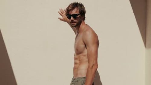 Attractive Man Posing Shirtless Near Wall