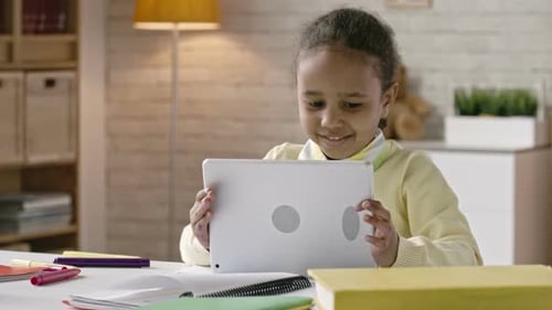 Child Using Tablet at Desk Indoors