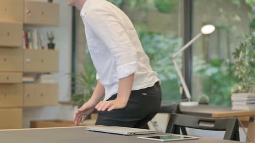 Junger Mann schließt Laptop und verlässt das moderne Büro