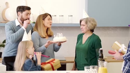 Family Celebrates a Birthday with Cake and Gifts