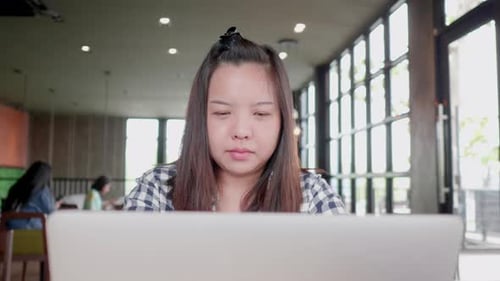 Freelancer Asian woman using laptop online working in coffee shop