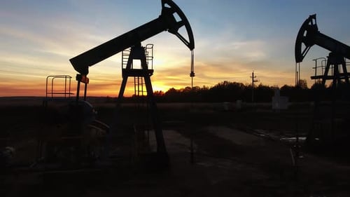 Silhouetted Pump Jacks Working at Sunset