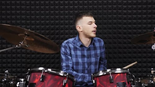 Drummer is preparing to play on drums at sound recording studio