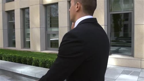 Young Businessman Out of the Building and Speaking on the Phone, Slow Motion