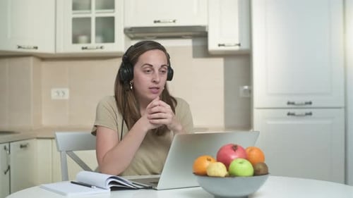 Woman Video Calling Using Laptop in Kitchen