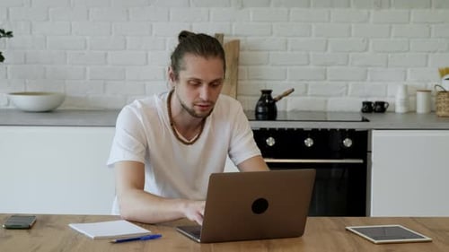 A Freelancer Works at a Laptop At Home, Sits at A Table in A Bright Room, Creates A New Project