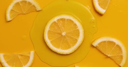 Top view rotation of fresh slice of lemons juice and gel serum