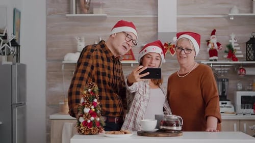 Festive Family Taking Christmas Selfie in Kitchen
