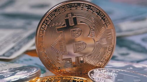 Bronze-Bitcoin-Münze, BTC und Dollarscheine rotieren