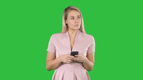 Woman Using Smartphone Against Green Screen