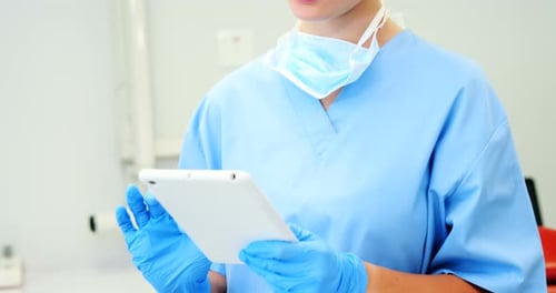 Female nurse using digital tablet in clinic