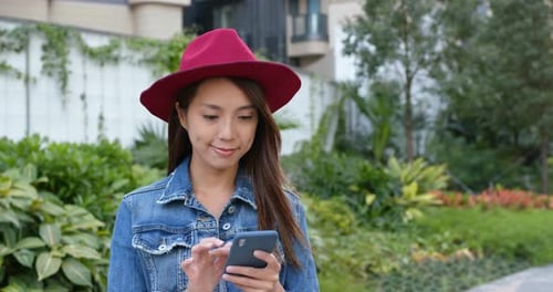 Woman Using Smartphone in Urban Park