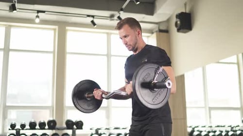Strong Young Man Doing Heavy Weight Exercise for Biceps.