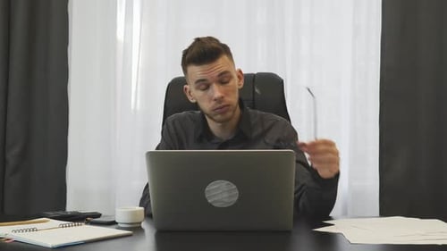 Man in suit takes off glasses and rubbing eyes after hard working day at office