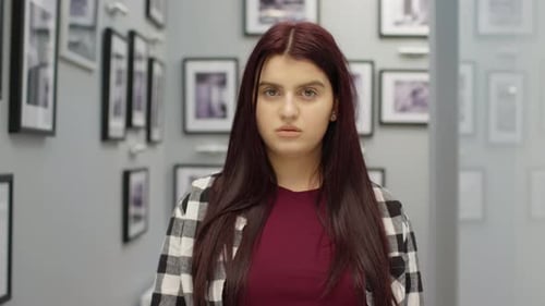 Young Woman Posing in Hallway with Pictures