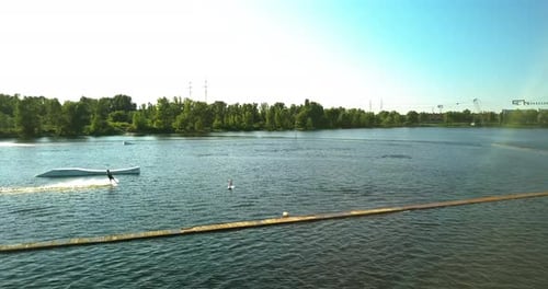 Aerial View of the Anchorage of the Cable Car Wake Park and an Athlete Cutting Through the Water on