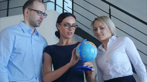 Drei Lehrer diskutieren etwas mit Globe