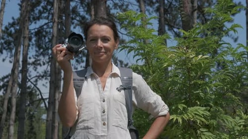 Woman Posing With Camera in Pine Forest