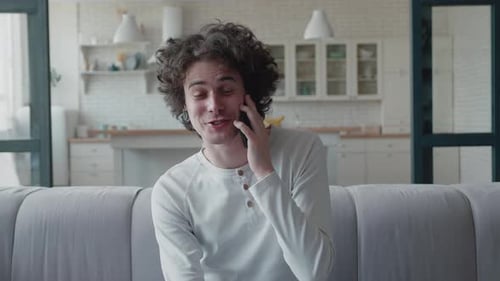 Young Man Talking On Smartphone at Home