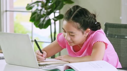 A girl doing her school work with laptop. Distance learning and online education concept.