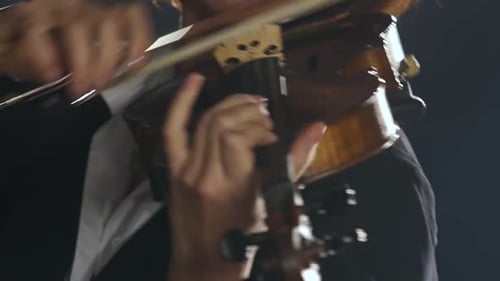 Girl Plays the Violin a Composition in a Dark Smoky Room. Close Up