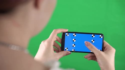 Smartphone with Tracking Points and Alpha Compositing in Female Hands Who is Swiping Up and Down