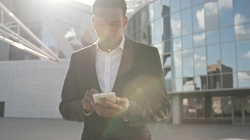 Businessman Typing Message on Mobile Phone
