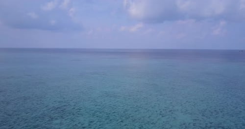 Wide fly over travel shot of a white paradise beach and turquoise sea background in colorful 4K