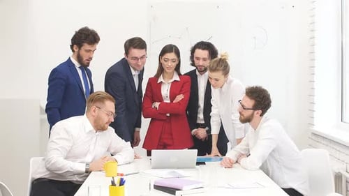 Diverse Team Collaborating on Laptop in Modern Office