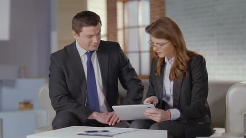 Business Meeting: Man and Woman Review Tablet
