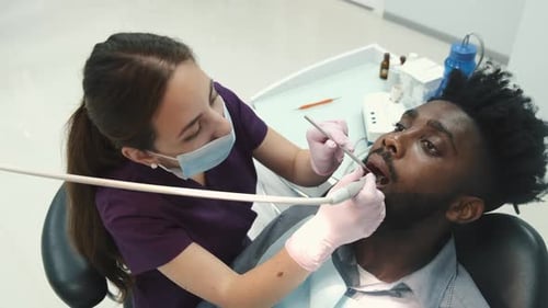 Dentist Examining a Patient's Teeth in the Dentist Office