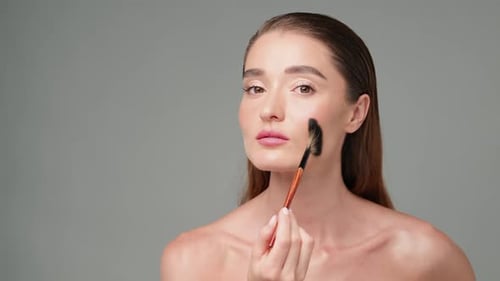 Woman Applying Makeup with a Fan Brush