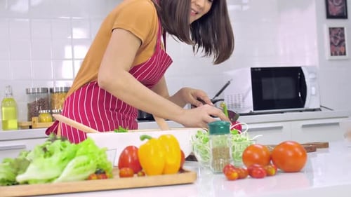 Young Woman Prepares Healthy Salad in Kitchen