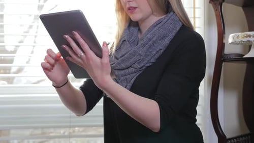 Woman Using Tablet Device Indoors by Window