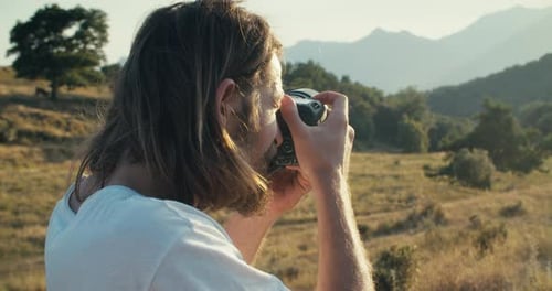 Portrait of Male Travel Photographer Make a Shot on Digital Camera on Mountain