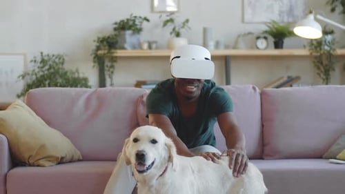Man with VR Headset and Dog on Couch