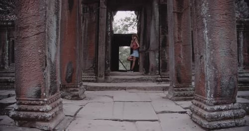A Young Blonde Woman Poses Inside an Ancient Ruins
