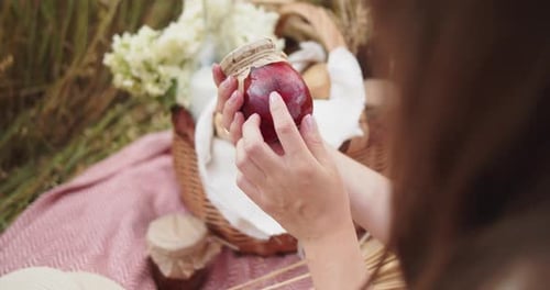Person Holds Jar of Preserves at Rural Picnic