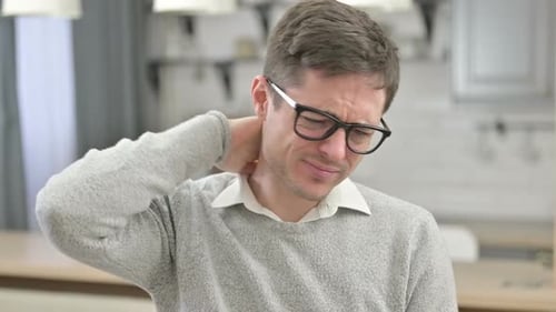 Man Rubbing Neck in Discomfort