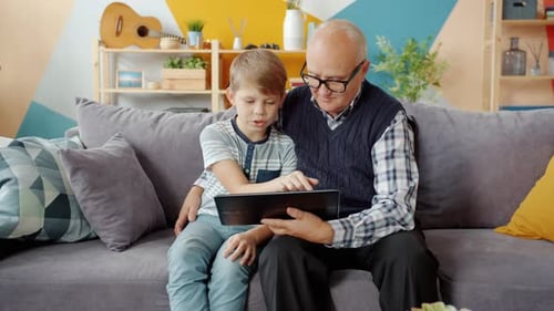 Grandfather and Grandson Looking at Tablet Together