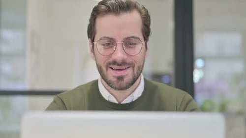 Close Up of Young Businessman Talking on Video Call on Laptop