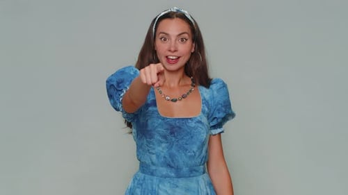 Hübsches Mädchen lächelt aufgeregt und zeigt auf die Kamera und wählt glücklichen Gewinner, der anzeigt, dass