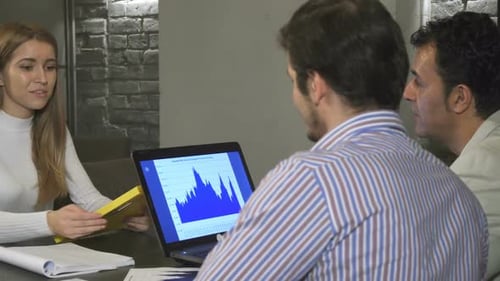 Business People Talking About Data on Laptop